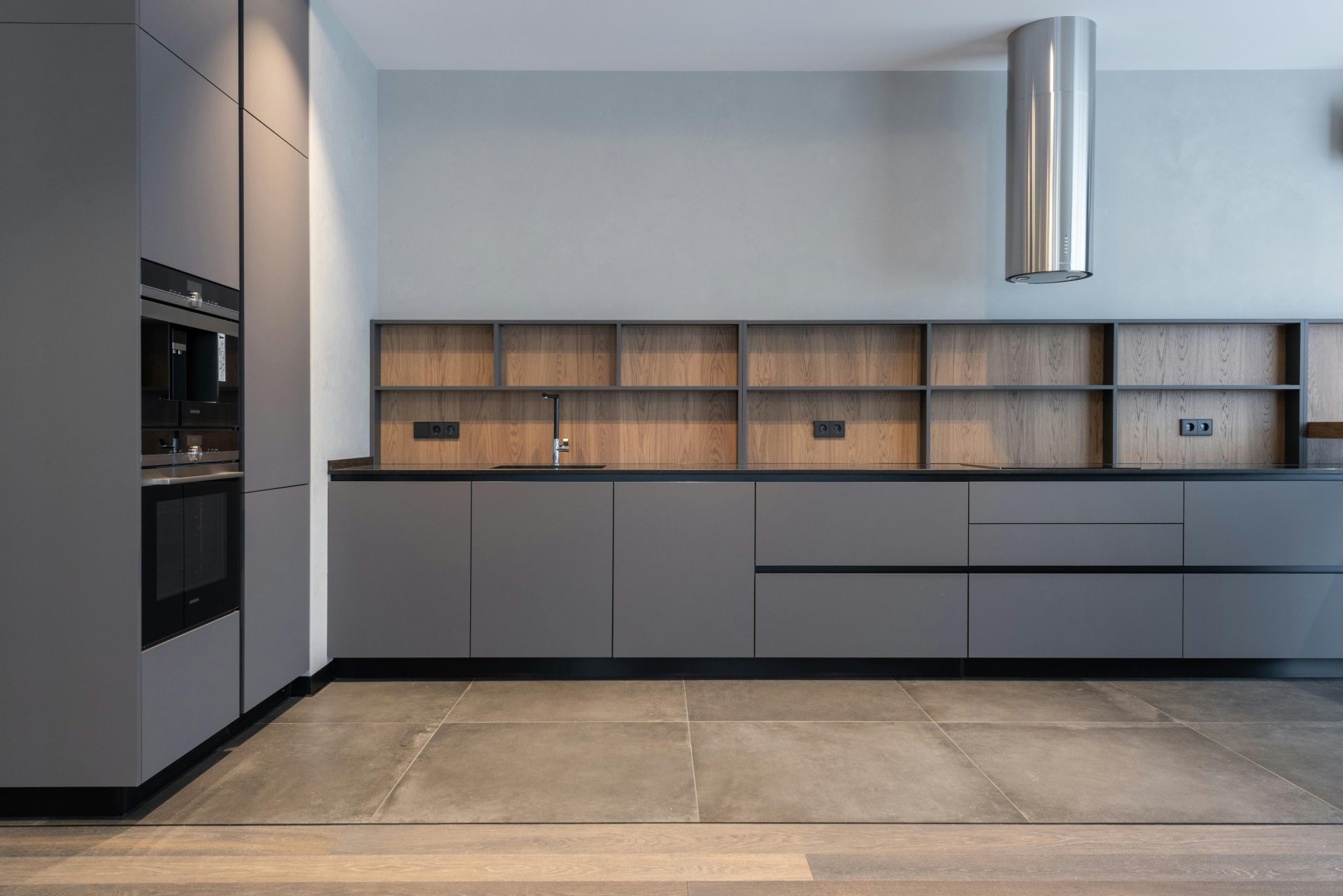 Spacious and sleek modern kitchen with minimalist gray cabinets and efficient layout.
